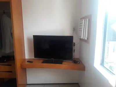 Uma televisão e/ou sistema de entretenimento em ApartHotel - Praia Mansa 1 e 2 Qtos