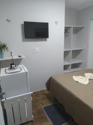 Uma televisão e/ou sistema de entretenimento em Pousada Suítes Meireles