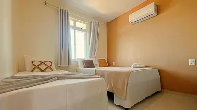 Uma cama ou camas num quarto em 2 suítes temporada - VENTILADO E NASCENTE, condomínio tranquilo com PISCINA, CHURRASQUEIRA E PLAYGROUND I Cozinha completa, estacionamento coberto, home office I Ideal para FAMÍLIAS E CASAIS I Prox do BEACH PARQUE e PRAIA - Porto das Dunas - CE