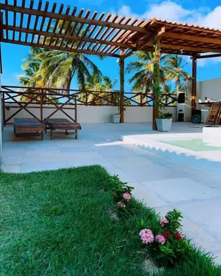 Um jardim no exterior de Casa Dférias Icaraizinho - piscina, cascata hidro