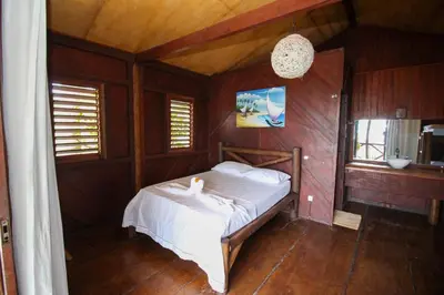 Uma cama ou camas num quarto em Pousada Palm Beach Praia de Caetanos Chalé Família