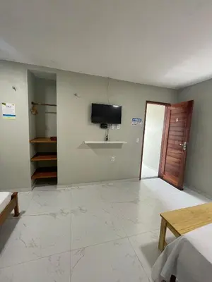Uma televisão e/ou sistema de entretenimento em Suítes Paraíso Perfeito