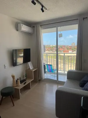 Uma televisão e/ou sistema de entretenimento em Apartamento em frente à praia conforto completo