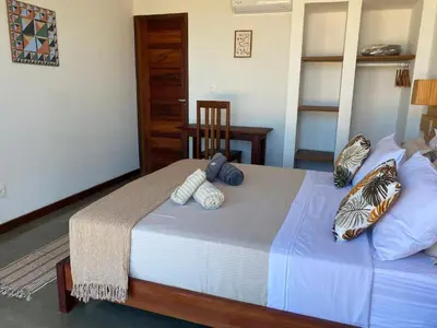 Uma cama ou camas num quarto em Vila éden praia suítes