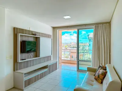 Uma televisão e/ou sistema de entretenimento em Porto das Dunas Apê na Areia com Banheira Relaxante e acesso direto para a praia! Ideal para Famílias, Lazer e Conforto