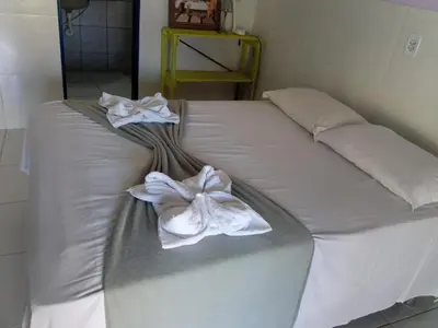 Uma cama ou camas num quarto em Pousada Bê kite cauipe