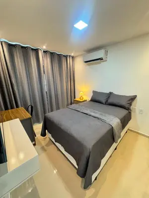Uma cama ou camas num quarto em AP completo próx ao Shopping com piscina, garagem e ar
