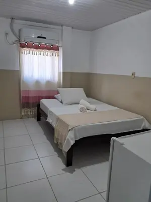 Uma cama ou camas num quarto em Pousada Sol do Centro
