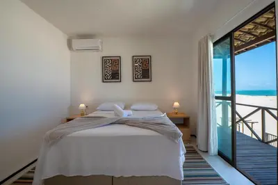 Uma cama ou camas num quarto em Beachfront Duplex Pé na Areia By Carpediem