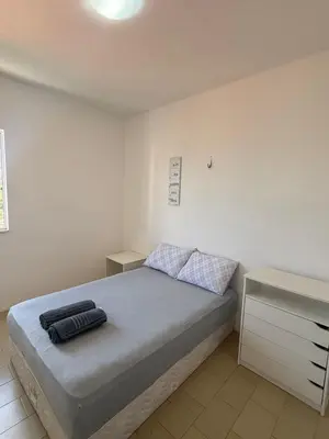 Uma cama ou camas num quarto em APT ventilado, 2 quartos, pertinho da praia