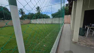 Um jardim no exterior de Casa de praia com campo de futebol e piscina