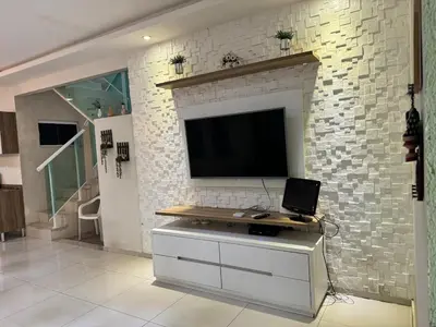 Uma televisão e/ou sistema de entretenimento em Casa completa com 3 quartos,ar e garagem