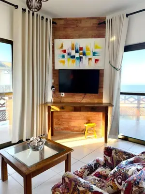 Uma televisão e/ou sistema de entretenimento em Apartamento frente para o Mar na Praia das Fontes