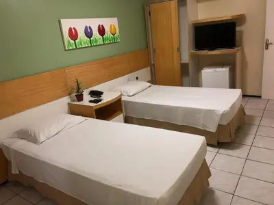 Uma cama ou camas num quarto em Raio de Sol Praia Hotel