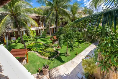 Um jardim no exterior de Vila Coqueiros Boutique Hotel