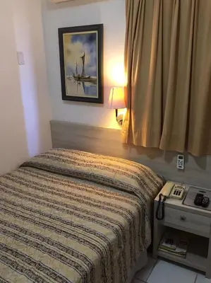 Uma cama ou camas num quarto em Ideal Praia Hotel