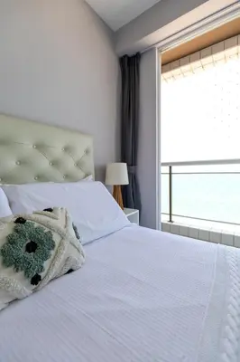 Uma cama ou camas num quarto em Modern Beachfront Apartment w. Magnificent Seaview
