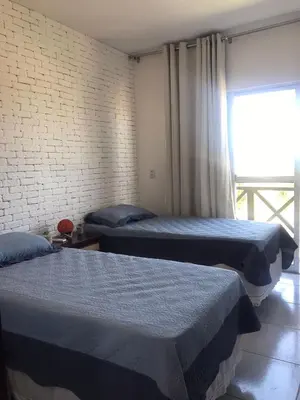Uma cama ou camas num quarto em Apartamento com vista para o mar, piscina , deck , playground e estacionamento .