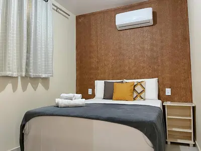 Uma cama ou camas num quarto em TOP 2 QUARTOS em Condominio- PISCINA, CHURRASQUEIRA, ESTACIONAMENTO, PARQUINHO INFANTIL, Wi-Fi e home office, Ar Condicionado, SmarTV e Cozinha Completa I 800m da praia e parque aquatico CE