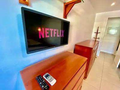 Uma televisão e/ou sistema de entretenimento em Condomínio Mediterranee Residence por Be My Guest
