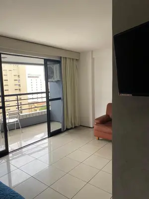 Uma televisão e/ou sistema de entretenimento em Flat com vista para o Mar