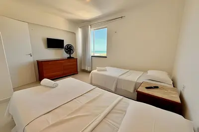 Uma cama ou camas num quarto em Apartamentos e Suítes na Praia
