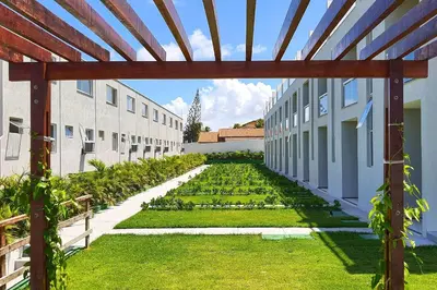 Um jardim no exterior de Beach Townhouses #C19 - Triplex por Carpediem